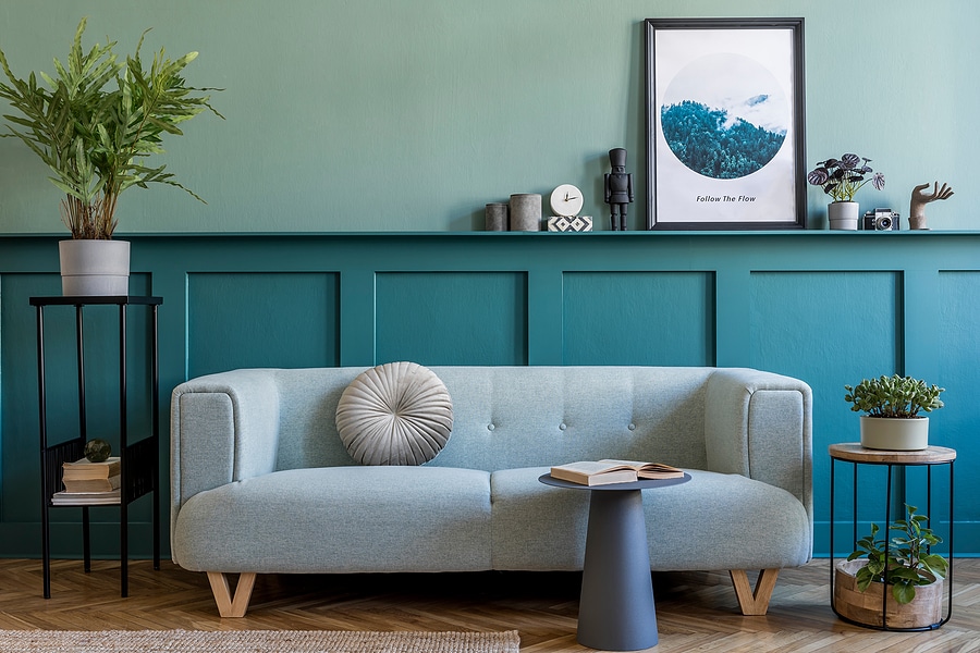 Stylish open-concept living room with layered green wall tones, light blue sofa, and natural decor accents—showcasing a harmonious color scheme ideal for flow and cohesion in open layouts.